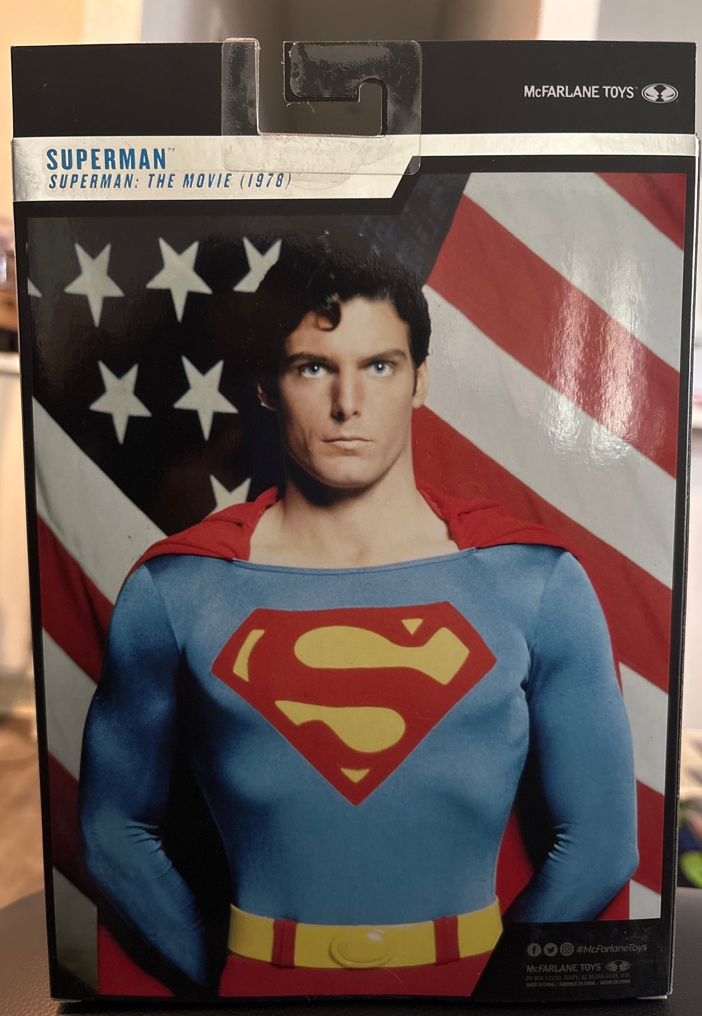 Superman action figure packaging with American flag background