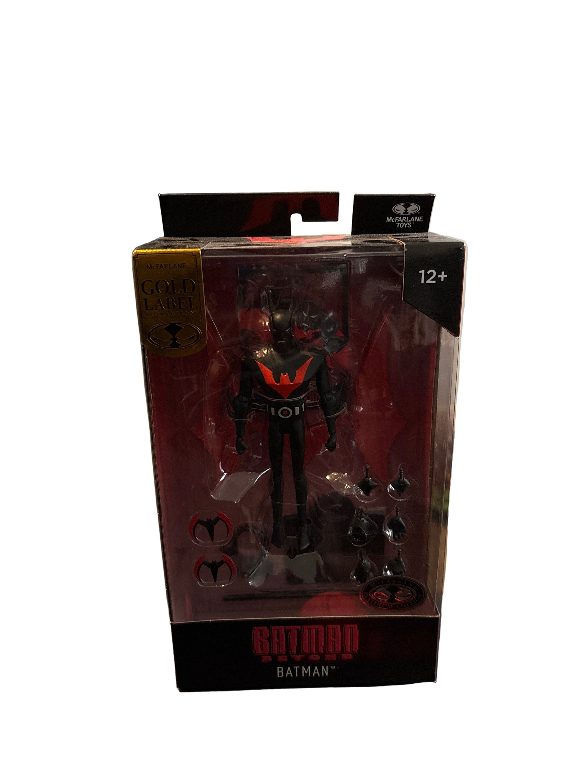 Toy figure in packaging with 'Batman' branding on a blurred background